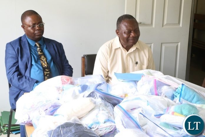 Church of God National overseer Bishop Joseph Ndashe flanked Bishop Michael Siwela with gives Christmas gift to a patient Esther Zulu at Liteta Hospital during the giving of Christmas presents