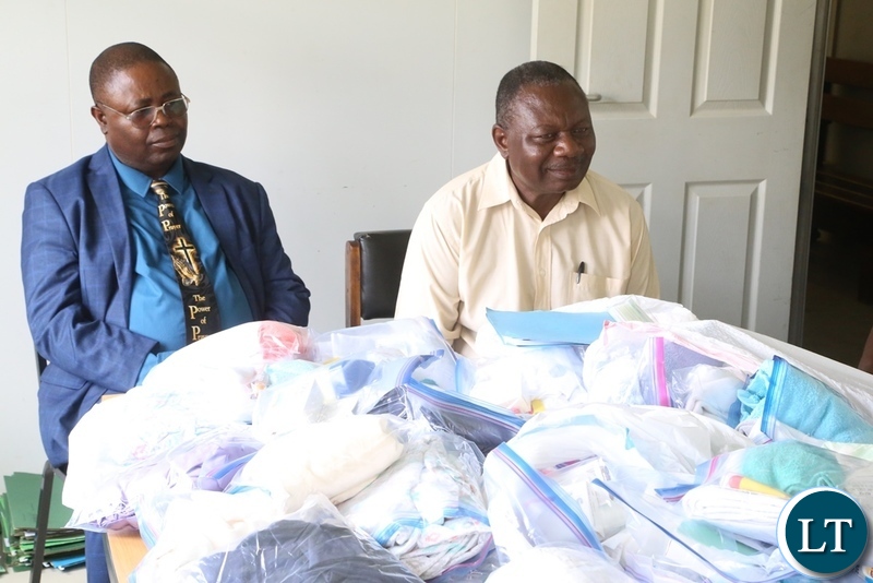 Church of God National overseer Bishop Joseph Ndashe flanked Bishop Michael Siwela with gives Christmas gift to a patient Esther Zulu at Liteta Hospital during the giving of Christmas presents