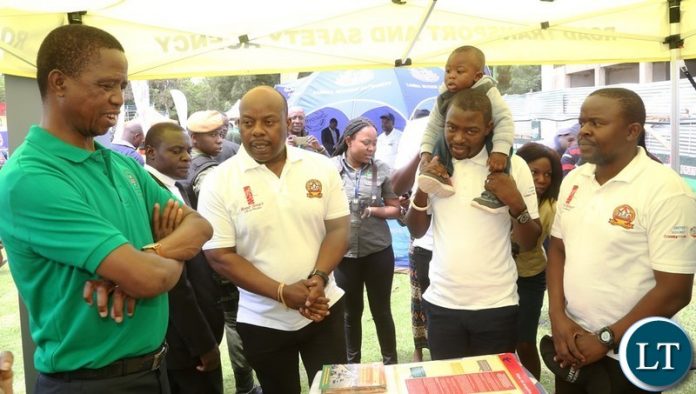President Edgar Lungu confers with RTSA Staff at the Stand of Road Transport Safety Agency Stand during the tour of stands at the commemoration of 2018 International Anti-Corruption Day at Show grounds