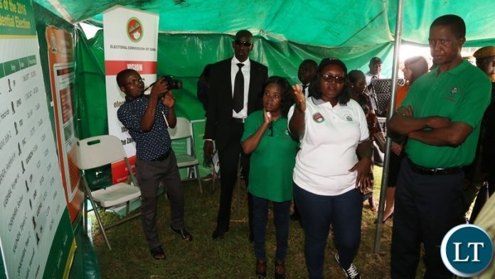 ECZ Voters Education Manager Emmah Mwiinga explains a point to President Edgar Lungu during the tour of stands at the commemoration of 2018 International Anti-Corruption Day at Show grounds