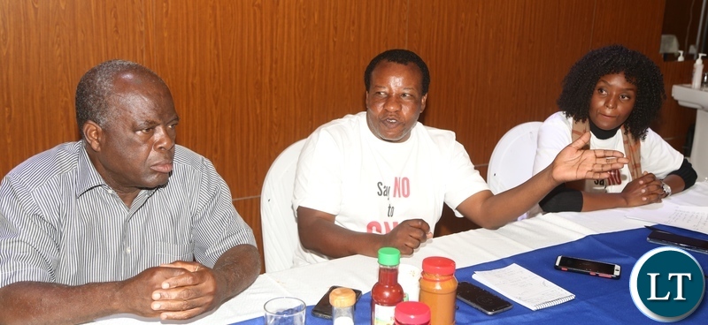 Caritas Zambia Executive Director Eugene Kabilika flanked by Community Technology Development Trust, member of Zambia Alliance for Agroecology and Biodiversity (ZAAB) Juliet Nangamba Luo (r) and Small Scale former Robert Chimambo (l) speaking during ongoing National Concerns over Biosafety and GMO policy Shift media briefing at Kapingila House