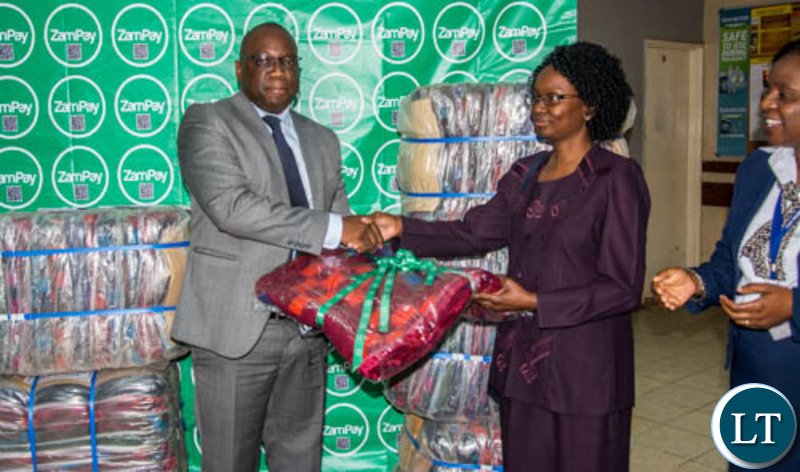 Zamtel Corporate Affairs Manager Chibeza Ngoma hands over blankets and linen to UTH Mother and Newborn Hospital Acting Senior Medical Superintendent Dr. Selia Nganjo during a Valentine Day donation at UTH