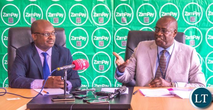 Bank of Zambia Deputy Governor (Operations) makes a point during a press briefing to announce the intergration of ZamPay on Visa and MasterCard as Zamtel CEO Mr Sydney Mupeta looks on