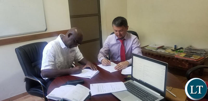 AB Bank Chief Credit Officer Nurullo Mashrabov signs the MoU with Medeem Business Development Manager Musenge Nsakilwa.