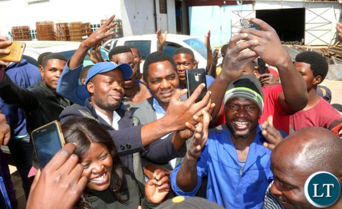HH takes selfies with youths working in the Lusaka industrial area