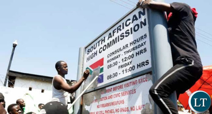 UNZA students burning the sign outside the South African Embassy in Lusaka during a demonstration to protest against xenophobic attacks in South Africa