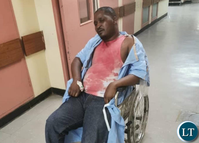 Pep Leader Sean Tembo covered in blood in a wheel chair at UTH