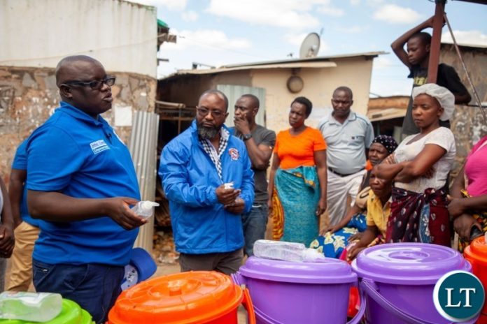 Peoples Alliance for Change President Andyford Banda distributing hand wash basins to Marketeers