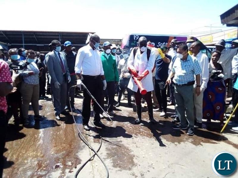 Minister of Local Government Charles Banda leading a team who conducted a sanitising exercise for flash mini buses and the entire millennium bus station