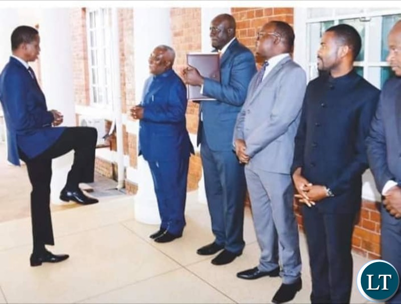 President Lungu demonstrating the new way to greet to Presidential Affairs Minister Hon Feedom Chomba Sikazwe