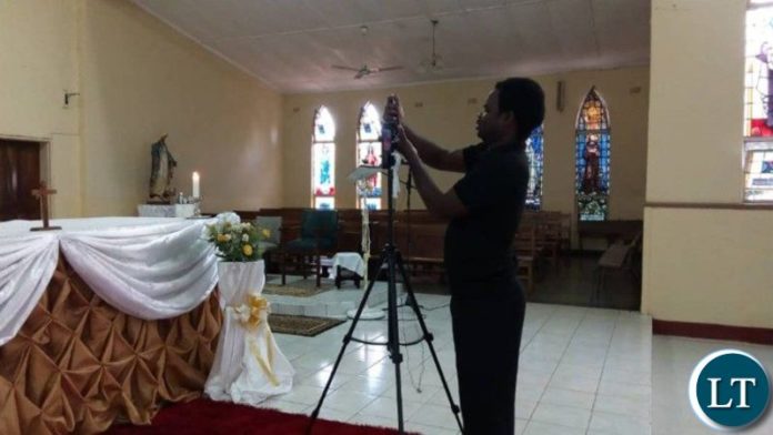 Joseph Phiri, a youth at St Theresa's Cathedral, Livingstone, Zambia setting up for live streaming of the Eucharist