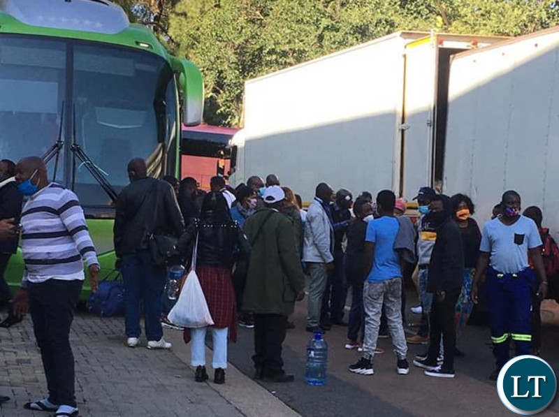 Returning Zambians waiting to board the buses