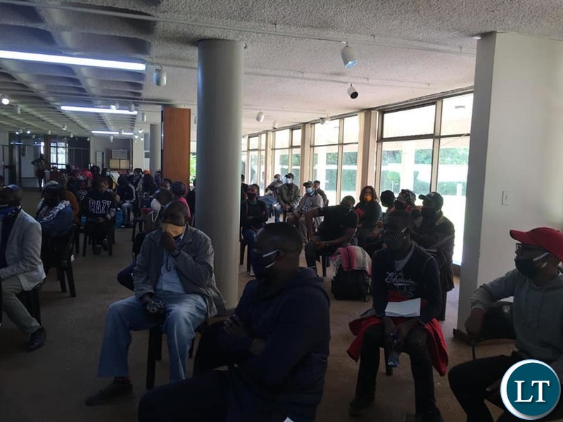 Returning Zambians waiting to board the buses