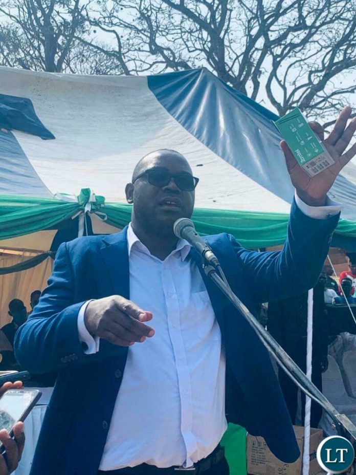 Transport and Communications Minister Mutotye Kafwaya displays a Zamtel handset and SIMCard to villagers during the launch of a Zamtel tower at Shibwalya Kapila village in Lunte District