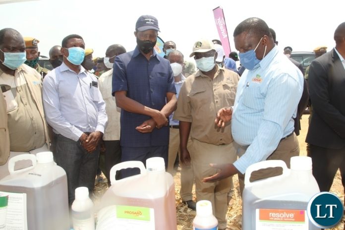 President Edgar Lungu is shown some chemicals used pest control by Mr Addson Ngoma Area Sales Manager central of Buyer Zambia during a mini exhibition at the launch of the national wheat harvest at chobe Agrivision farm in Mkushi district central province