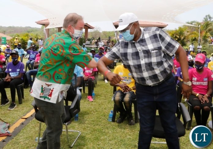 Ministry of Health Permanent Secretary for technical services Dr Kennedy Malama in an elbow greeting with United States of America Charged- Affairs David Young during the back to school Coronavirus awareness entertainment programme in Lusaka,s new Kasama