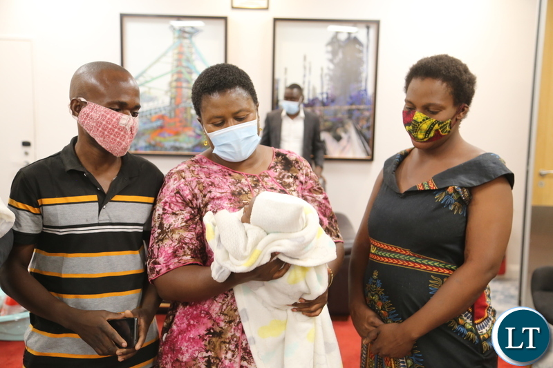 -Minister in the office of the Vice President Olipa Phiri admires one of the babies whilst the mother of quadrato babies Elizabeth Phiri Bwalya Father Daniel Bwalya looks on during the presentation of the gifts to the babies Edgar, Jeremiah, Jessy and Esther the only female