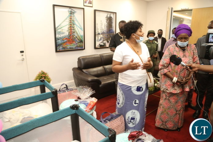 Minister of Community Development Kampamba Chewe stress a point to the Vice President Inonge Wina during the presentation of the gifts to the quadrto (4) babies Edgar, Jeremiah, Jessy and Esther the only female in Kitwe