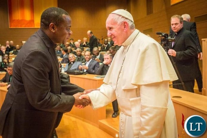 Fr Emmanuel Mumba shaking hands with the Pope