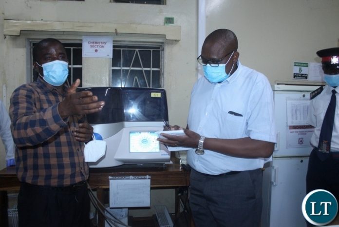 Ministry of Health Technical Services Permanent Secretary Dr. Kennedy Malama (r) taking notes as Lewanika General Hospital Principal Biomedical Scientist Chiswamo Phillips explains (l) during the tour of health facilities in Mongu Ministry of Health Technical Services Permanent Secretary Dr. Kennedy Malama (r) taking notes as Lewanika General Hospital Principal Biomedical Scientist Chiswamo Phillips explains (l) during the tour of health facilities in Mongu