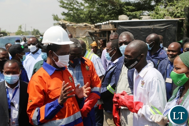 President Edgar Lungu confers with mandevu councillorTeddy Mwaba  during the drainage clean up exercise in Lusaka.