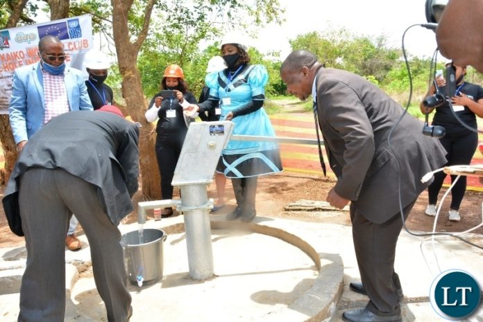 Ministry of Mines Director of Geological Survey Chipilauka Mukofu operating the pump donated to Kanyanja Community during the launch of Kaiko Women's Club Bore hole initiative in Shantumbu.Looking on is Kaiko Women's Club Chairperson Getrude Mundia.