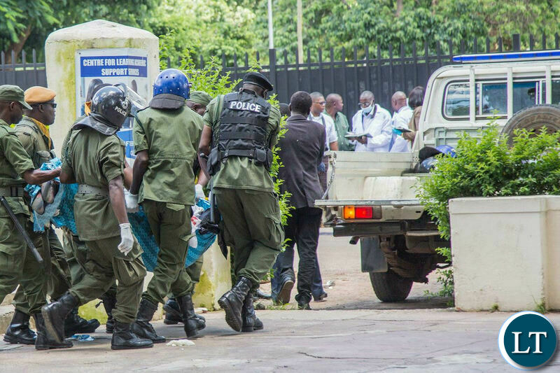  Zambia Police officers remove the body of a government worker who was shot as opposition leader Hakainde Hichilema was being questioned at Police Headquarters.