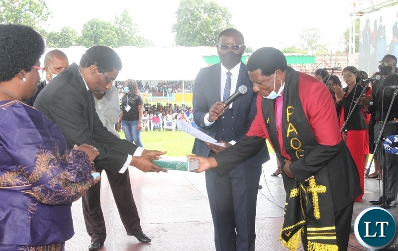 Pentecostal Assemblies of God(PAOG), Bishop Dr.David Banda receives a bible from immediate -past Presiding Bishop ,Robertson Nonde during the installation of presiding Bishop and unveiling presentation of full council of bishops in Lusaka.