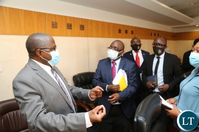 Minister of Commerce , Trade and Industry Christopher Yaluma confers with Permanent Secretary Ministry of Commerce, Trade and Industry, Mr. Mushuma Mulenga and others staffed shortly after media briefing on the effects and efforts of the pricing of goods at his office yesterday, February 18, 2021. Picture by ROYD SIBAJENE/ZANIS