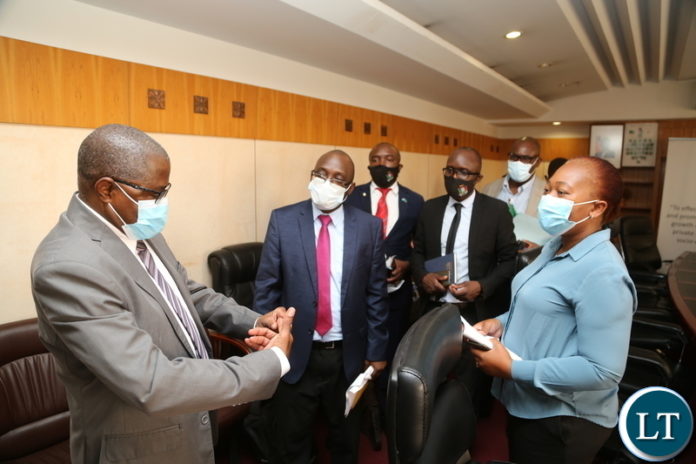 Minister of Commerce , Trade and Industry Christopher Yaluma confers with Permanent Secretary Ministry of Commerce, Trade and Industry, Mr. Mushuma Mulenga and others staffed shortly after media briefing on the effects and efforts of the pricing of goods at his office yesterday, February 18, 2021. Picture by ROYD SIBAJENE/ZANIS