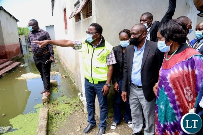 DMMU National Coordinator Chanda Kabwe showing the flooded area to the Vice President Inonge Wina during the tour of the flooded kuku compound DMMU National Coordinator Chanda Kabwe showing the flooded area to the Vice President Inonge Wina during the tour of the flooded kuku compound