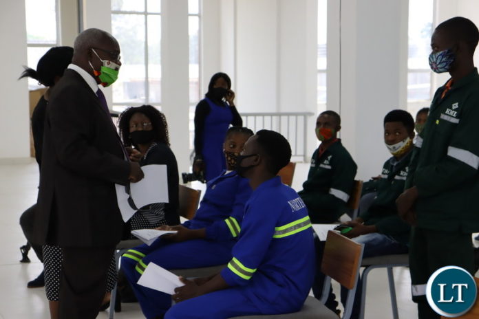 FIRST Quantum Minerals (FQM) Government relations specialist Godwin Beene (left) confers with Nortec students sponsored by Trident Foundation during the donation of laptops.
