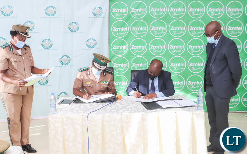 Zambia Correctional Service Commissioner General Dr Chisela Chileshe and Zamtel CEO Mr Sydney Mupeta signing an MoU to digitalise operations of the Correctional Service
