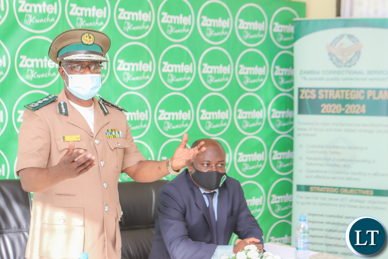 Zambia Correctional Service Commissioner General Dr Chisela Chileshe speaking during the signing ceremony as Zamtel CEO Sydney Mupeta listens on