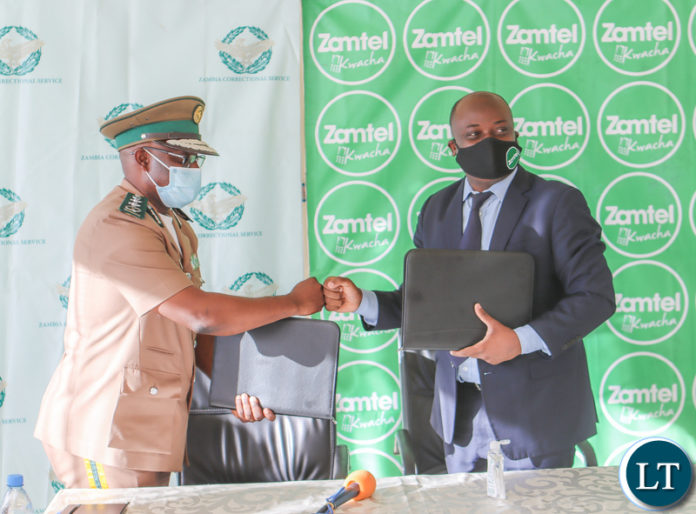 Zambia Correctional Service Commissioner General Dr Chisela Chileshe and Zamtel CEO Mr Sydney Mupeta exchange fist bumps during the signing ceremony of an MoU to digitalise operations of the Correctional Service Zambia Correctional Service Commissioner General Dr Chisela Chileshe and Zamtel CEO Mr Sydney Mupeta exchange fist bumps during the signing ceremony of an MoU to digitalise operations of the Correctional Service