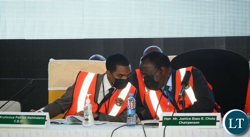 ECZ Chairperson Hon Justice Esau Chulu and ECZ Chief Executive Officer Patrick Nshindano share notes during the Electoral Commission of Zambia announcement of results at the National Results Center Mulungushi in Lusaka