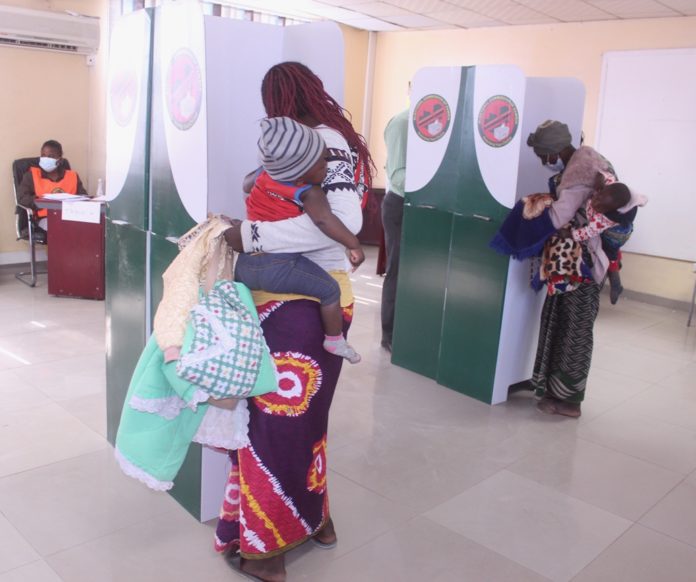 Polling assistants verifying the names of voters at Kamulanga Primary School in Kabwata Constituenc
