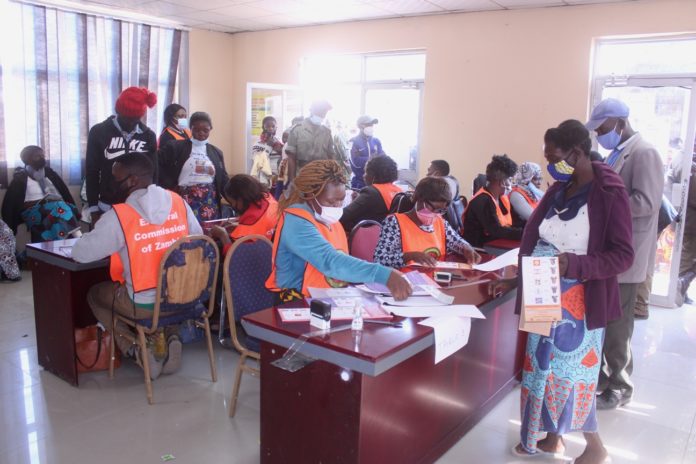 Polling assistants verifying the names of voters at Kamulanga Primary School in Kabwata Constituenc