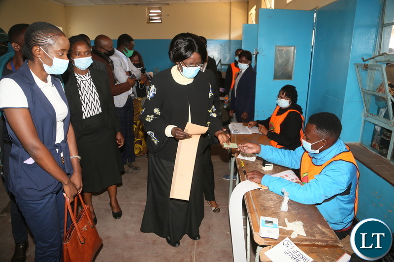 Vice President Inonge Wina receive the ballot papers from the polling assistant at silverest polling in Chongwe District 