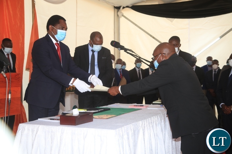 PRESIDENT Hakainde Hichilema receives an affidavit form from Newly sworn in Minister of Defence Hon.Ambrose Lufuma at swearing -in ceremony in Lusaka
