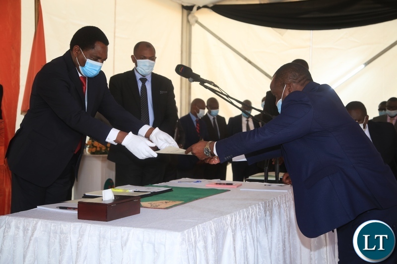 PRESIDENT Hakainde Hichilema receives an affidavit form from Newly sworn in Minister of Home Affairs at swearing -in ceremony in Lusaka.