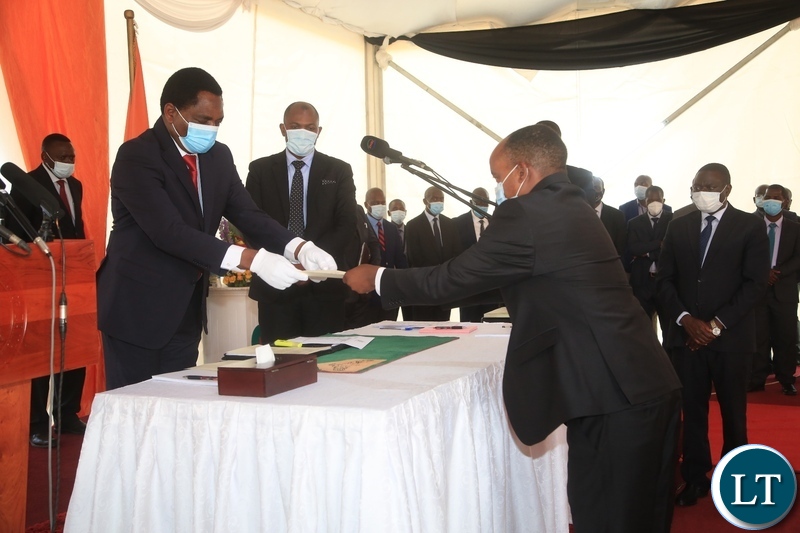 PRESIDENT Hakainde Hichilema receives an affidavit form from Newly sworn in Southern Province Minister,Cornelius Mweetwa at swearing -in ceremony in Lusaka