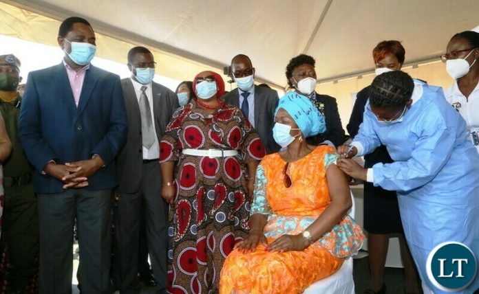Health Personnel Mutinta Habaalu giving a vaccine ejection to Health Minister Sylvia Masebo whilst President Hakainde Hichilema looks on during the relaunch of COVID-19 vaccine at OYDC Health Personnel Mutinta Habaalu giving a vaccine ejection to Health Minister Sylvia Masebo whilst President Hakainde Hichilema looks on during the relaunch of COVID-19 vaccine at OYDC