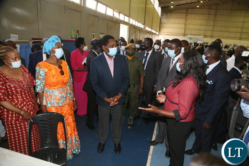 Lusaka District Public Health Specialist Dr. Gladys Muyembe explains a point to President Hakainde Hichilema flanked by Minister of Health Sylvia Masebo, Lusaka Province Minister Sheal Mulyata during the relaunch of COVID-19 vaccine at OYDC