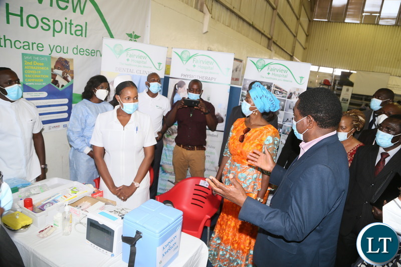 President Hakainde Hichilema confers with nurses when he toured the stands during the relaunch of COVID-19 vaccine at OYDC