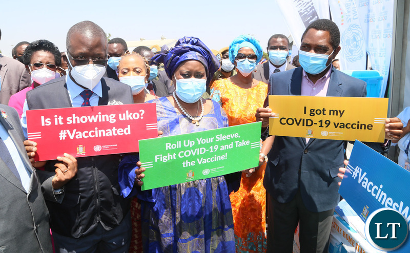 President Hakainde Hichilema with UN country coordinator Caumba Mar Gadio and Dr. Nathan Bakayta hold high the placards during the relaunch of COVID-19 vaccine at OYDC