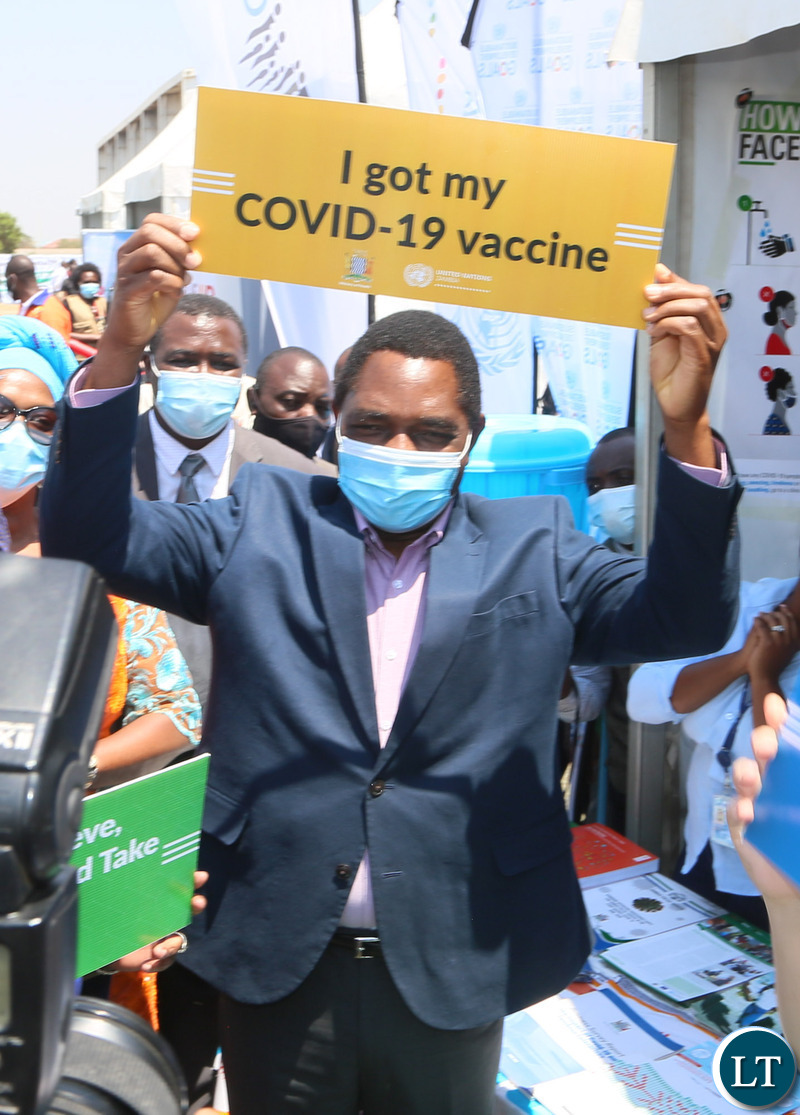 President Hakainde Hichilema hold high a placard showing is vaccinated during the relaunch of COVID-19 vaccine at OYDC