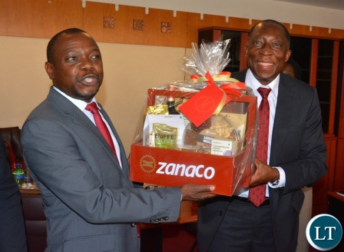 Minister of Small and Medium Enterprise, Elias Mubanga receives a gift from Chairperson of Zanaco Board ,Hastings Mtine when management paid a courtesy call on him in Lusaka