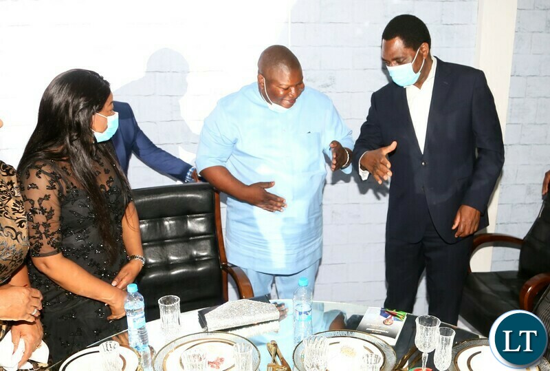 President Hakainde Hichilema shake hands with Kaystech Energy Chief Executive Jonathan Kondowe  after bidding the K2.5 million for Coat ofduring the Gala Dinner and meet the President at Mulungushi Conferance Center whilst First lady Mutinta Hichilema looks on