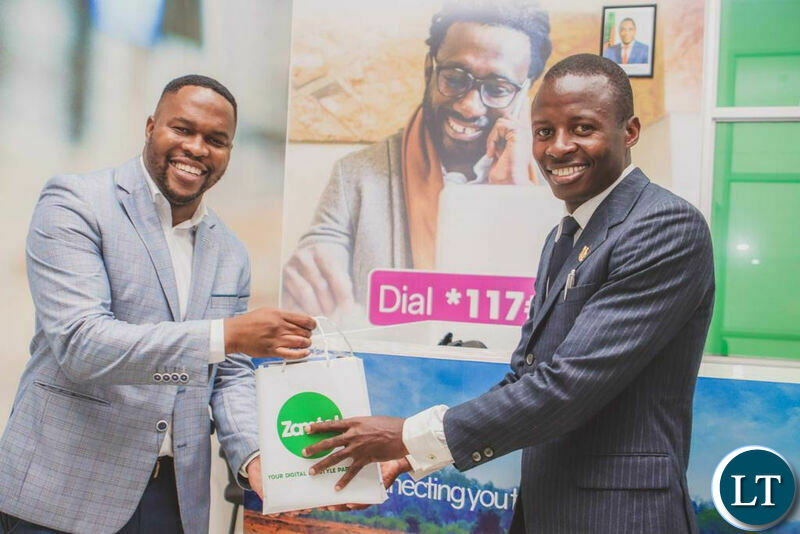 Zamtel Acting Chief Commercial Officer Keith Banda hands a gift to Kalingalinga Ward 36 Councillor Mukubesa Nyoni after the opening of Zamtel Kamloops Customer Service Centre